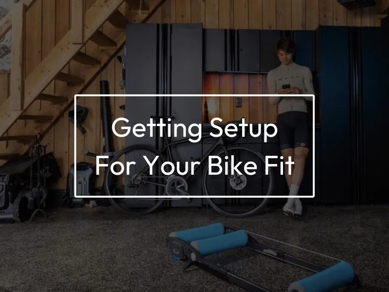 Man standing beside bike while looking at MyVeloFit software on his phone.