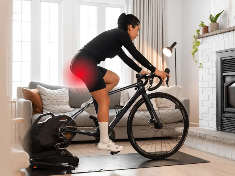Cycling Related Foot Pain - MyVeloFit woman on bike trainer with saddle discomfort
